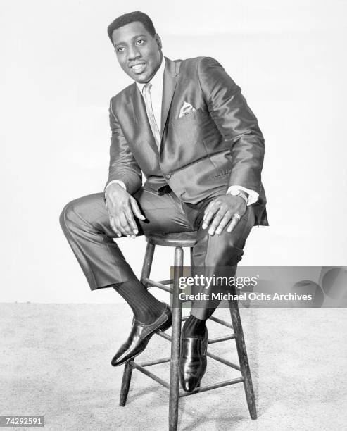 Soul singer Otis Redding poses for a full length portrait sitting in a chair in 1965.