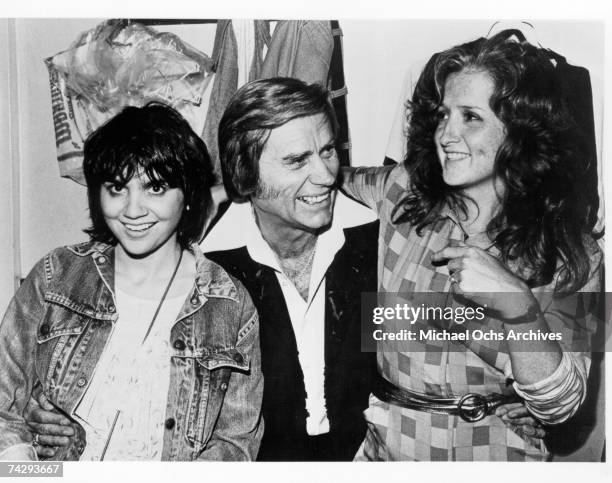 Singers Linda Ronstadt and Bonnie Raitt join country star George Jones backstage at the Bottom Line in September 1980 in New York City, New York.