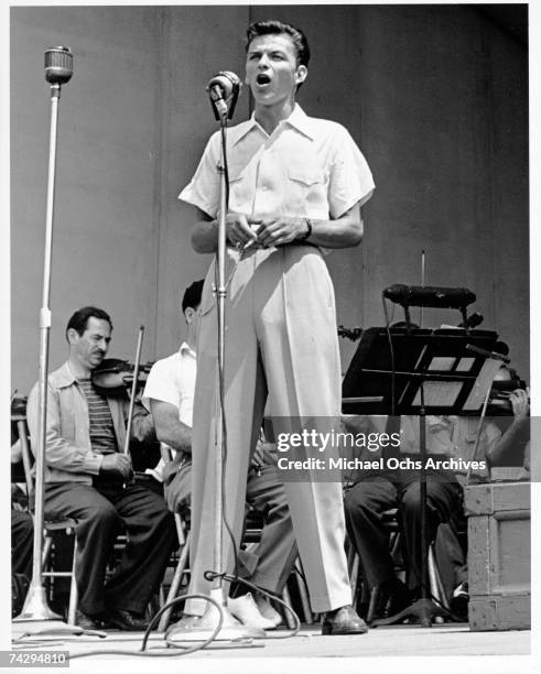 Pop singer Frank Sinatra performs onstage during a soundcheck with the Max Steiner orchestra at the Lewisohn Stadium on August 3, 1943 in New York...