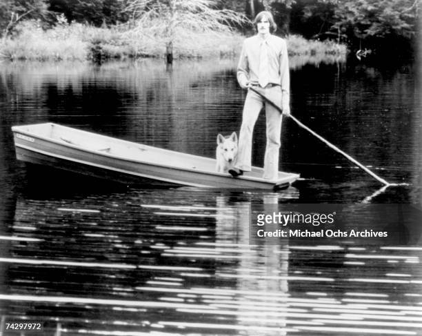 Singer/songwriter James Taylor poses for a portrait standing in a boat with a dog for the cover of his album "One Man Dog" which was released...