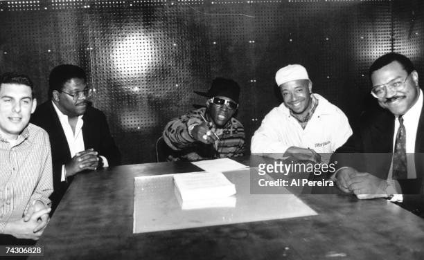 Record executive Lyor Cohen, a lawyer, rapper Flavor Flav, record executive Russell Simmons and a lawyer pose for a portrait as Flav signs a solo...