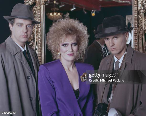 English pop singer Dusty Springfield posed with Neil Tennant and Chris Lowe of the Pet Shop Boys, dressed as 1960s journalists, studio portrait,...