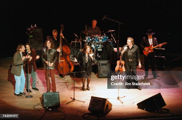 Married country singers Johnny Cash and June Carter Cash perform onstage with their band, including Dave Roe on bass, W.S. Holland on drums and Bob...