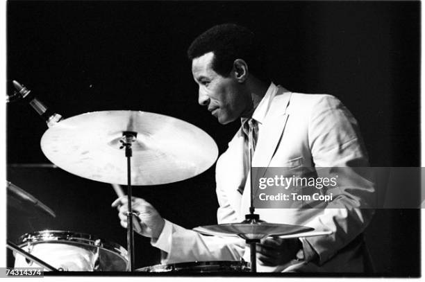 Jazz drummer Max Roach performs onstage wearing a white suit at the Newport Folk Festival on July 2, 1967 in Newport, Rhode Island.