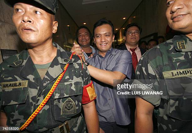 Philippine senatorial candidate and detained former Philippine navy officer Antonio Trillanes, , is escorted by his marine escorts moments after...