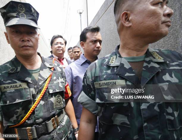 Philippine senatorial candidate and detained former Philippine navy officer Antonio Trillanes, , is led out of the suburban Makati Regional Trial...