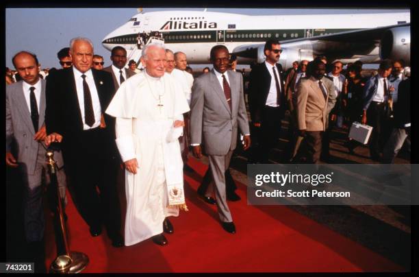 Pope John Paul II poses with Angolan President Jose Eduardo dos Santos at the international airport June 7, 1992 in Luanda, Angola. Angola has been...