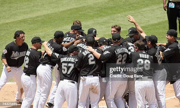 Josh Willingham of the Florida Marlins celebrates with teammates while crossing home plate after hitting a three-run home run in the bottom of the...