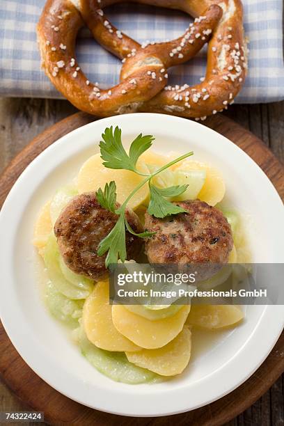 burgers on potato and cucumber salad with pretzel - potato salad stock-fotos und bilder