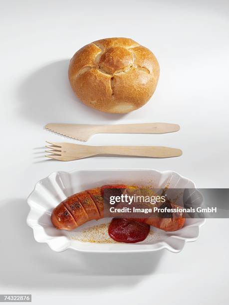 currywurst (sausage with ketchup & curry powder) with bread roll - currywurst stock pictures, royalty-free photos & images