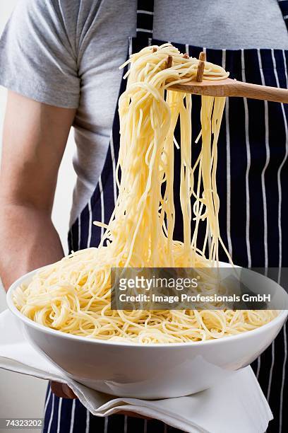 cooked spaghetti in a dish and on spaghetti server - utensile di portata foto e immagini stock