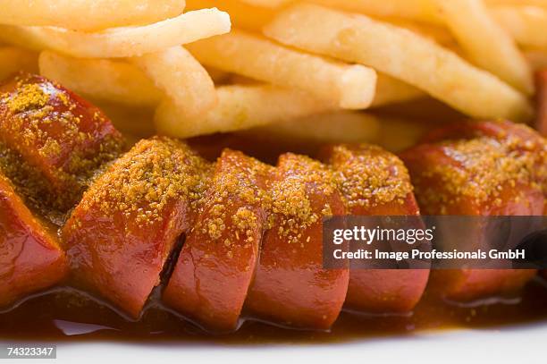 sausage, cut into slices, with ketchup and chips - currywurst stock pictures, royalty-free photos & images