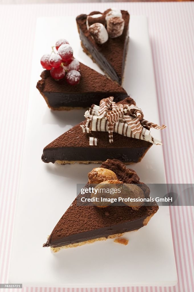 Four pieces of chocolate tart, with different decorations