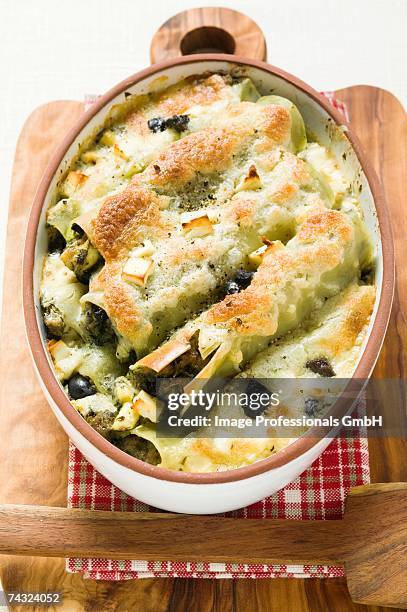 cannelloni with spinach & sheep's cheese filling in dish - cannelloni stock-fotos und bilder