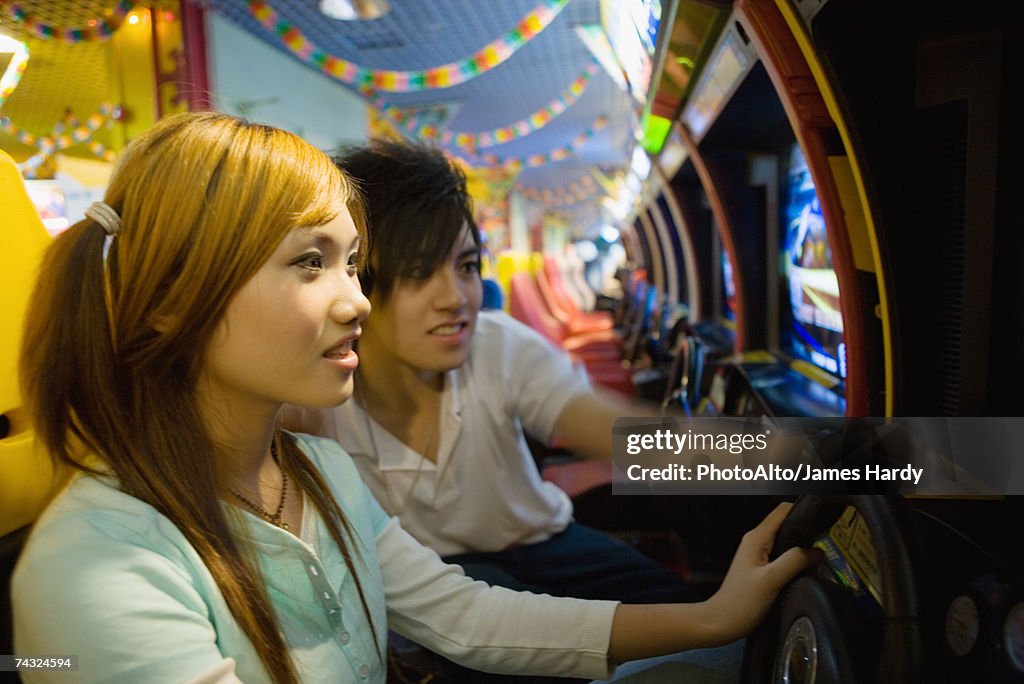 Teenage couple playing games in video arcade