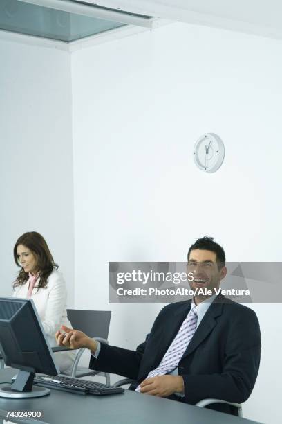 businessman sitting at desk, holding yin yang balls - slimy businessman stock pictures, royalty-free photos & images