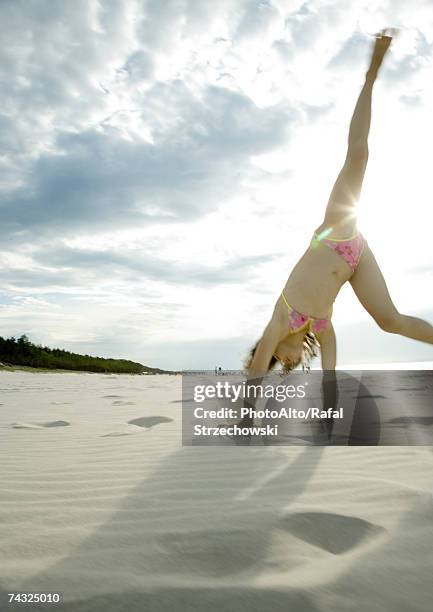 girl doing cartwheel on beach - cartwheel stock pictures, royalty-free photos & images