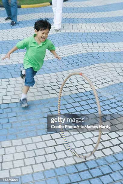 boy chasing hula hoop - hoop rolling stock pictures, royalty-free photos & images