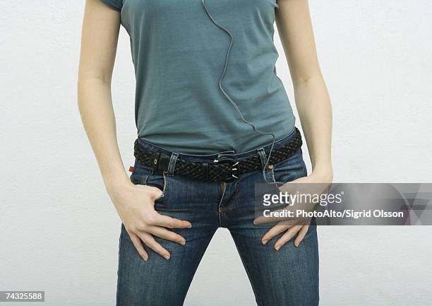 young woman standing with thumbs in jean pockets, close-up of mid section - legs apart imagens e fotografias de stock