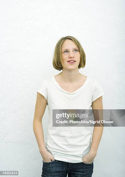 teenage girl standing with hands in pockets, looking up, portrait - girl who stands stock pictures, royalty-free photos & images