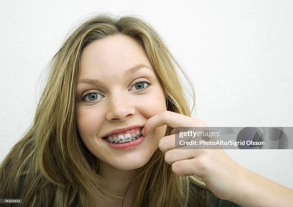 Teenage girl touching braces, portrait