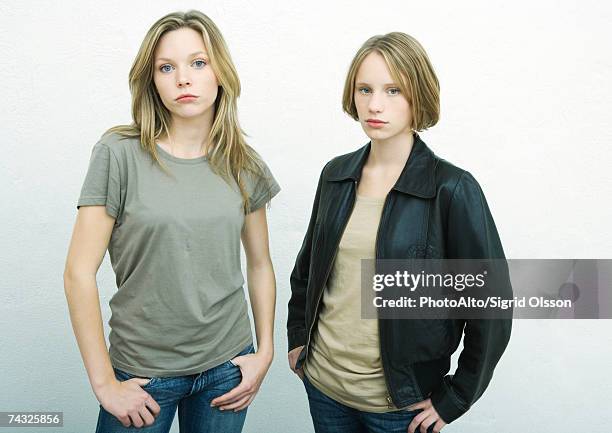 teenage girls standing side by side with hands on hips, looking at camera, portrait - alleen tienermeisjes stockfoto's en -beelden