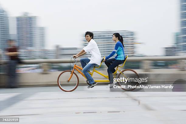 couple riding tandem bicycle - tandem bicycle foto e immagini stock