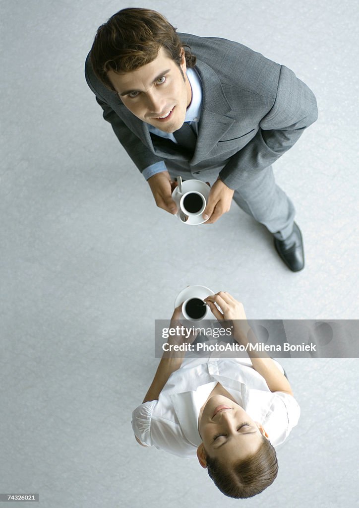 Male and female associates having coffee, full length, high angle view