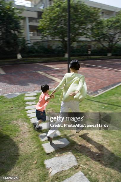 mother and son walking across grass in apartment complex - stepping stone top view stock pictures, royalty-free photos & images