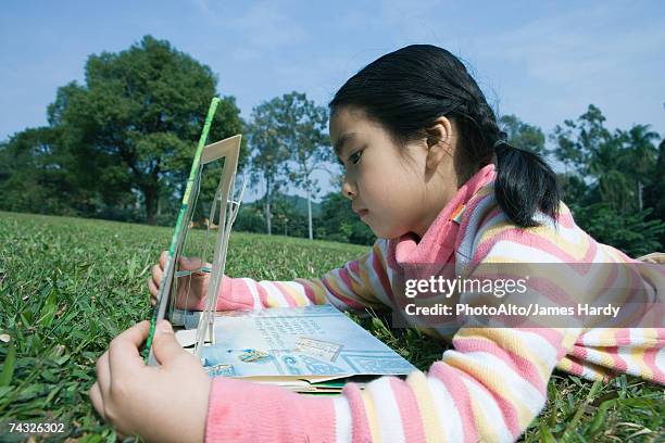 girl lying in grass with pop-up book - pop up book stock-fotos und bilder