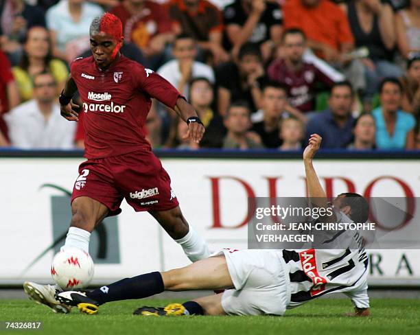 Longeville-les-Metz, FRANCE: Metz's French defender Franck Beria fights for the ball with Gueugnon's French midfielder Alexander Hauw during their...