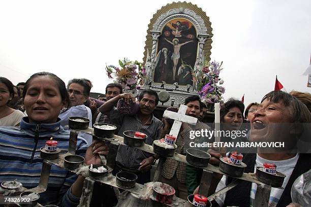 Comerciantes del mercado de Santa Anita cargan una imagen del Senor de los Milagros, al interior del Centro de Abastos en Lima, el 25 mayo 2007. La...