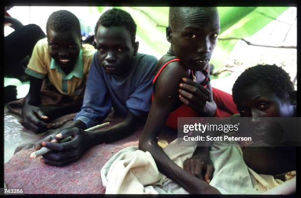 Sudanese "Lost Boys" huddle in a tent on June 18, 1992 at a refugee camp inside Kenya. Some 17,000 boys were lured away from home to receive military...