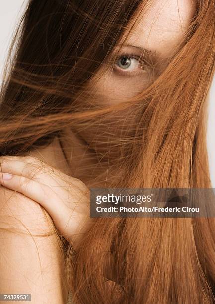 frau mit roten haaren auf der hälfte des gesichts - glattes haar stock-fotos und bilder