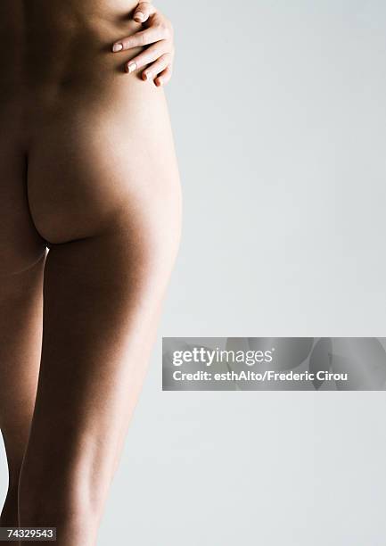 woman's bare buttocks and legs, hand on hip, partial view - bare bottom women stock-fotos und bilder