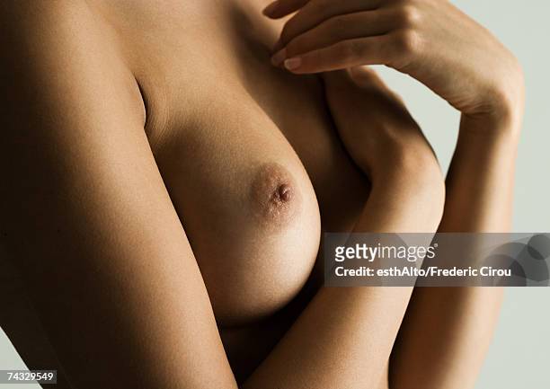 woman's bare chest, hands covering breast, close-up - brustwarze stock-fotos und bilder