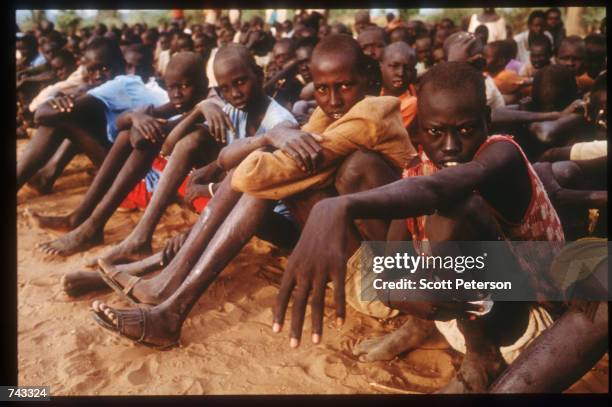 Sudanese refugees and "Lost Boys" sit together on June 18, 1992 at a camp inside Kenya. Some 17,000 boys were lured away from home to receive...