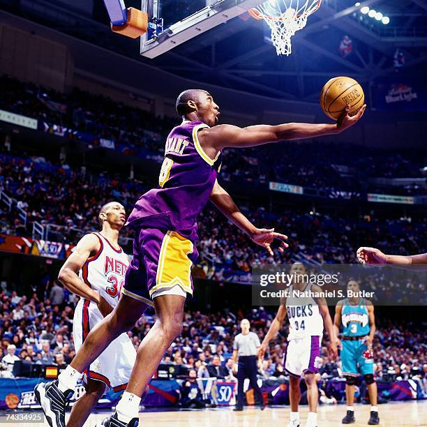 Kobe Bryant of the Western Conference attempts a reverse layup against Kerry Kittles of the Eastern Conference during the 1997 Rookie Game played...