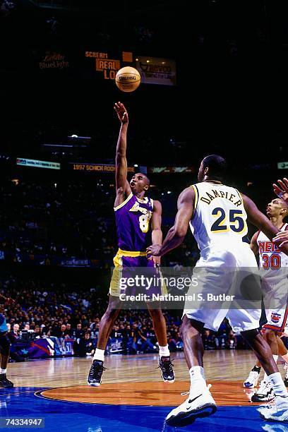 Kobe Bryant of the Western Conference attempts a shot against Erick Dampier of the Eastern Conference during the 1997 Rookie Game played February 8,...