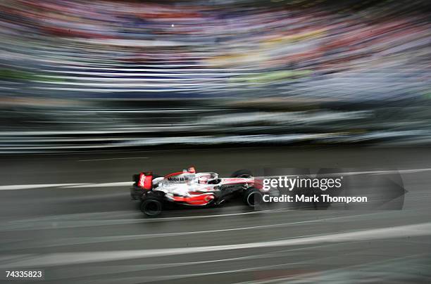 Fernando Alonso of Spain and McLaren Mercedes drives through Casino Square in the warm up session prior to qualifying for the Monaco Formula One...