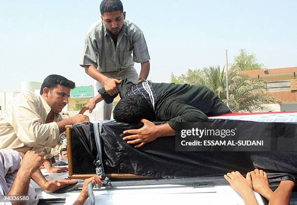 Iraqis mourn over the coffin of a Mahdi Army militant during his funeral in Iraq's southern port city of Basra, 26 May 2007. Shiite militiamen of the...