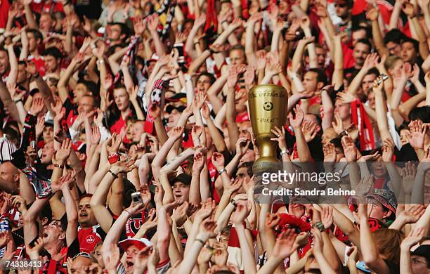 Replica mascot of the German Cup is held aloft amongst the crowd of Nuremberg fans prior to the DFB German Cup Final football match between VfB...