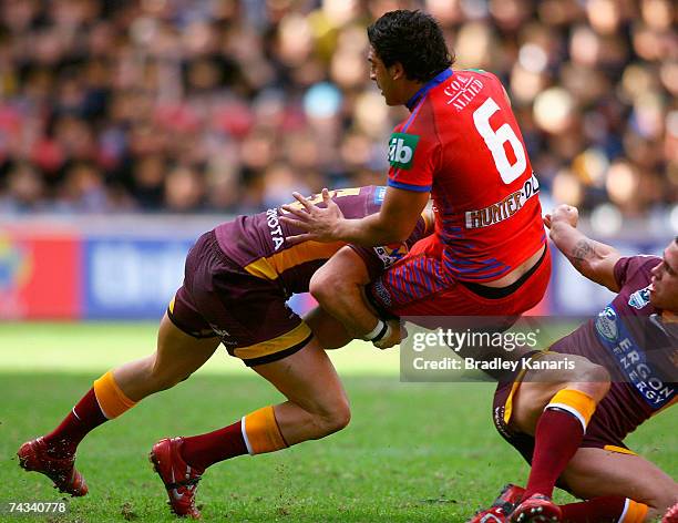 Marvin Karawana of the Knights is picked up and driven by Darius Boyd of the Broncos during the round 11 NRL match between the Brisbane Broncos and...