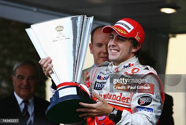 Fernando Alonso of Spain and McLaren Mercedes celebrates after being presented with the trophy by Prince Albert of Monaco for winning the Monaco...