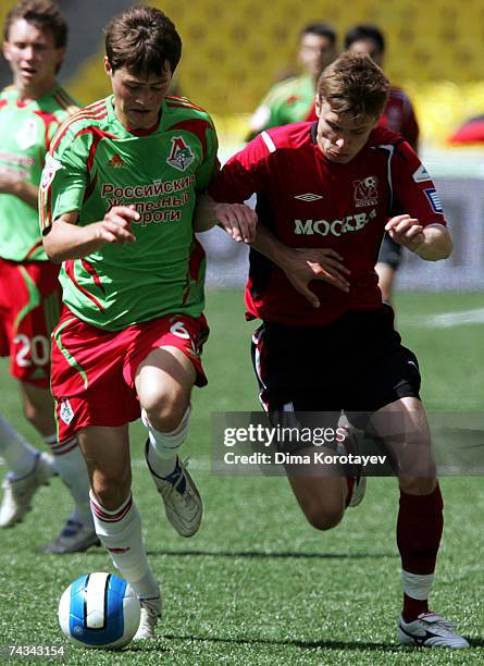 Kirill Nababkin of FC Moskva competes for the ball with Diniyar Bilyaletdinov of Lokomotiv Moscow during the Russian Cup final match between...