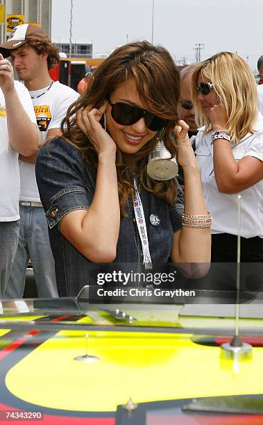 Actress Jessica Alba, watches as the crew of Elliott Sadler, driver of the Dodge Dealers/UAW Dodge, work on the car prior to the start of the NASCAR...