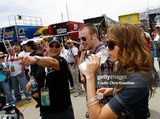 Actors Jessica Alba, Chris Evans and Michael Chiklis, watch as the crew of Elliott Sadler, driver of the Dodge Dealers/UAW Dodge, work on the car...