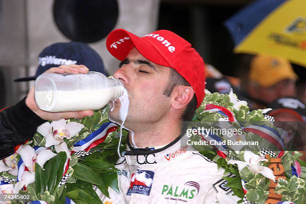 Dario Franchitti, driver of the Canadian Club Andretti Green Racing Dallara Honda celebrates with the traditional bottle of winner's milk in victory...