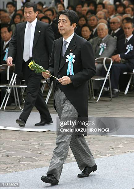Japanese Prime Minister Shinzo Abe offers a flower during an annual memorial service at Tokyo's Chidorigafuchi National Cemetery, the tomb for the...