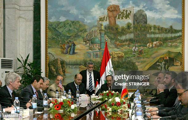 Ambassador to Iraq Ryan Crocker faces Iranian ambassador Hassan Kazemi and the Iranian delegation as Iraqi Prime Minister Nuri al-Maliki speaks...